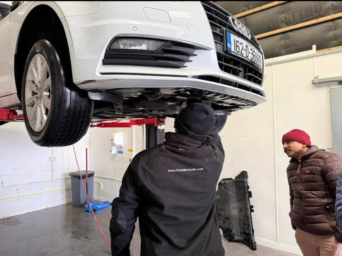 Mechanic working under Audi on lift